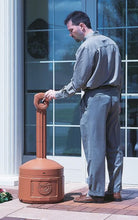 Load image into Gallery viewer, Man interacting with a large brown trash can outside a building.