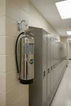 Load image into Gallery viewer, Silver fire extinguisher with a visible brand logo on a white background
